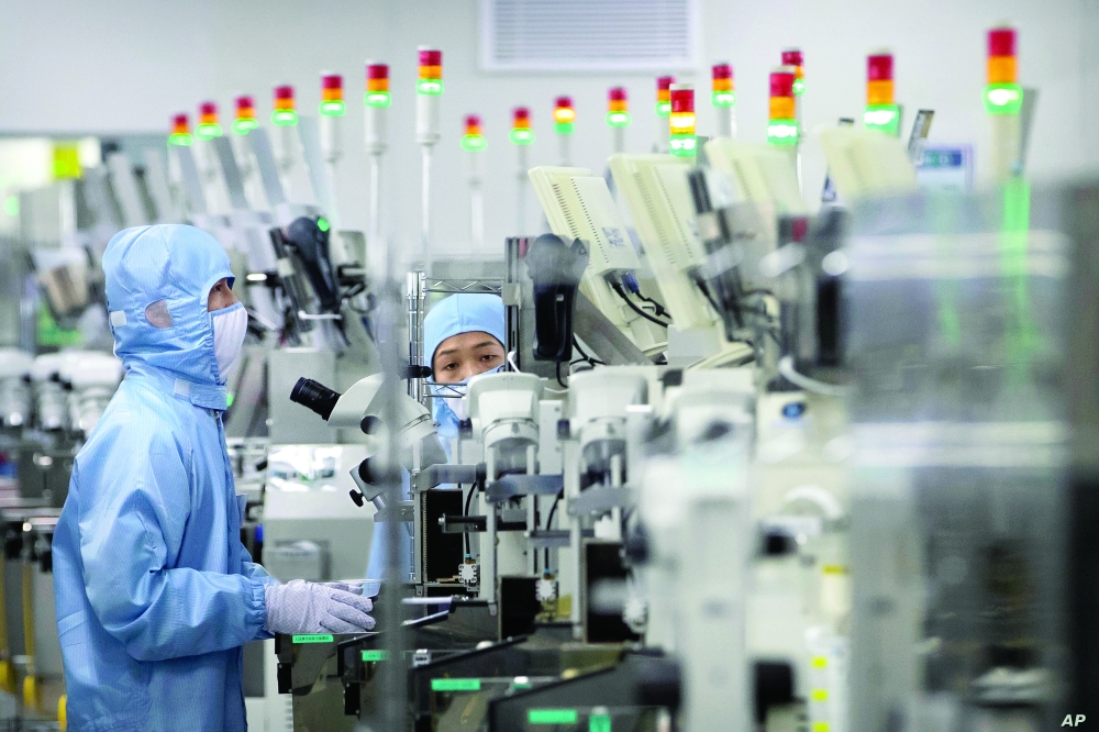 Employees wearing protective equipment work at a semiconductor production facility in Beijing. — Reuters 