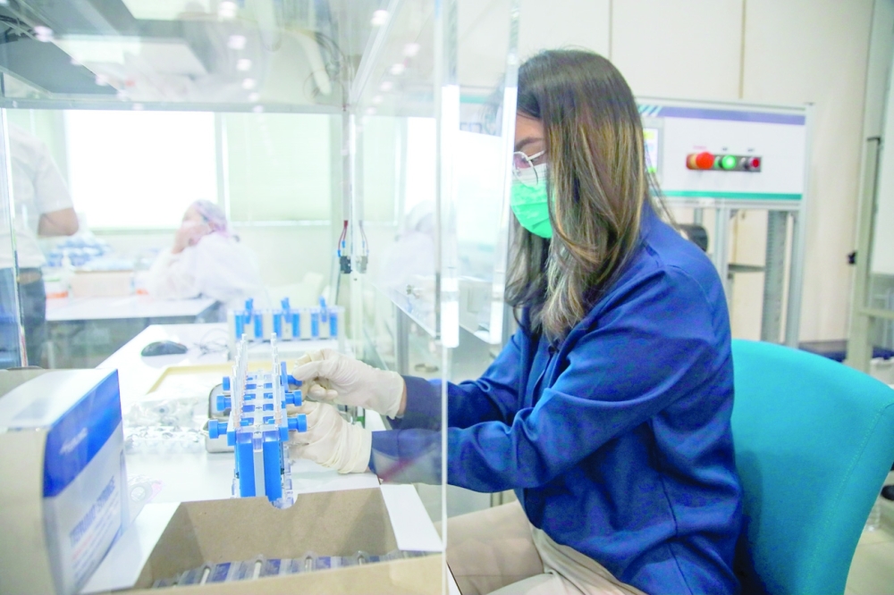 A technician works at AutoVacc vaccine extraction machine designed by the Chulalongkorn University's Biomedical Engineering Research Center to extract extra doses out of AstraZeneca vaccine vials in Bangkok. -- Reuters