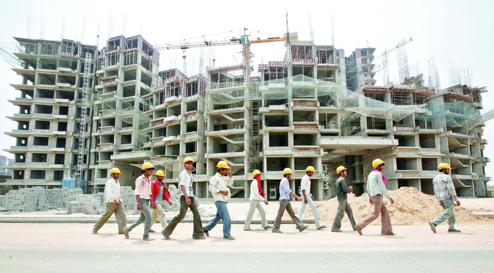 Workers walk in front of the construction site of a commercial complex on the outskirts of Ahmedabad, in this file photo. — Reuters