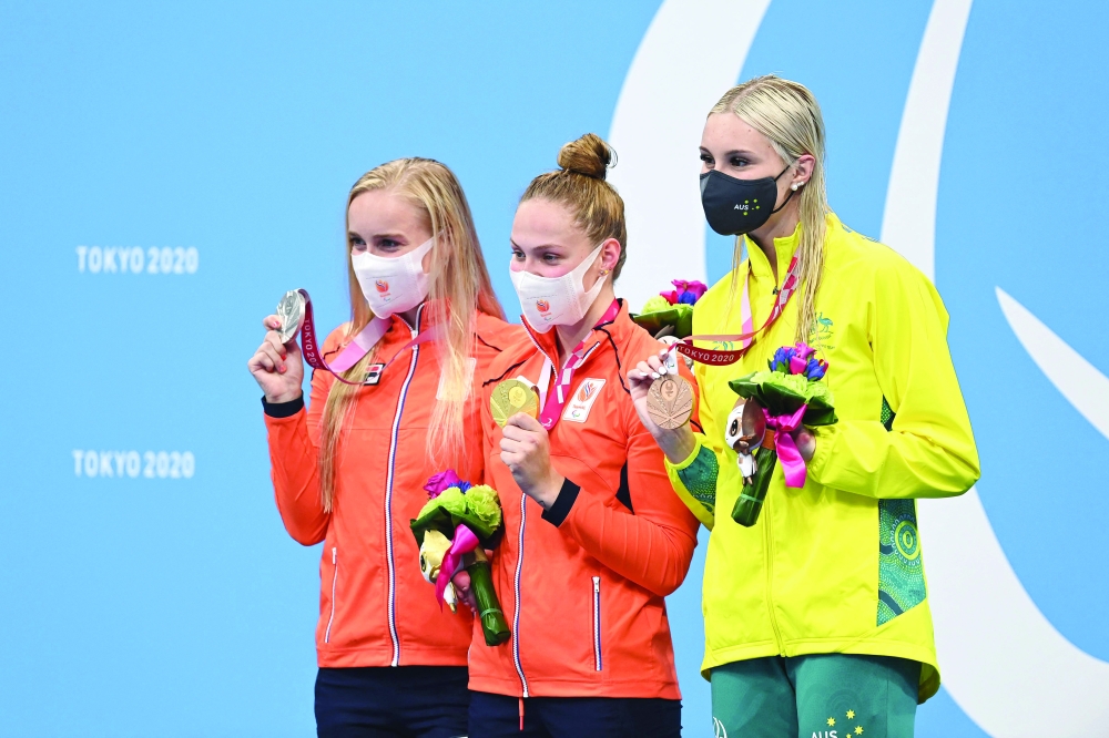 Gold medallist Netherlands' Chantalle Zijderveld (C), her compatriot silver medallist Lisa Kruger (L) and bronze medallist Australia's Keira Stephens pose on the podium after the women's 100m breaststroke (SB9) swimming event at Tokyo Aquatics Centre. -- AFP 