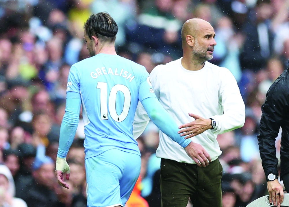 Manchester City's Jack Grealish with manager Pep Guardiola after being substituted. -- Reuters 