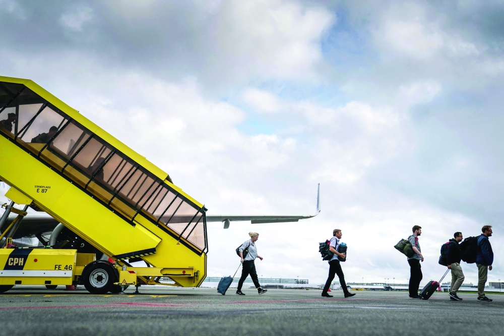 People disembark the last SAS plane carrying evacuees from Kabul in Afghanistan after it arrived at Copenhagen Airport. - AFP 