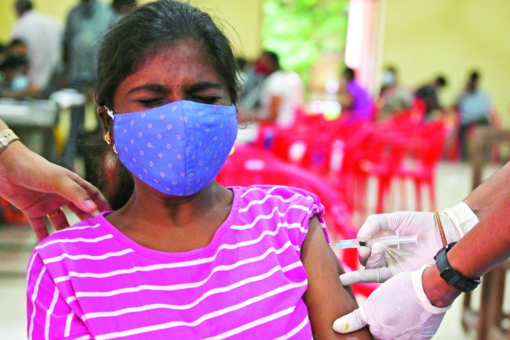 A woman gets inoculated with a dose of the Covid-19 coronavirus vaccine at a vaccination camp in Chennai on Saturday. -- AFP