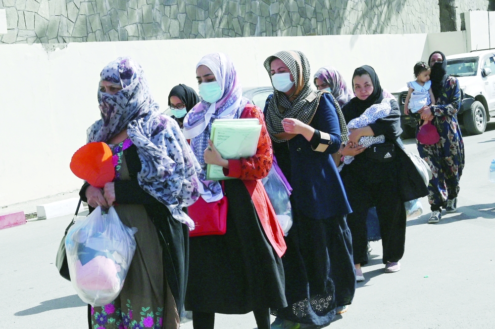 Women, hoping to leave Afghanistan, walk to the main entrance gate of Kabul airport in Kabul on Saturday. -- AFP
