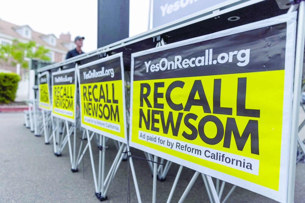 Signs are shown at a rally for the recall campaign of California governor Gavin Newsom in Carlsbad, California. - Reuters