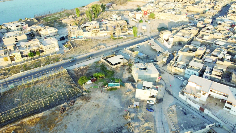 A general view of the Old City of Mosul as boys swim in a makeshift outdoor pool built by swimming coach Mahmood Muafaq, in Mosul, Iraq. - Reuters