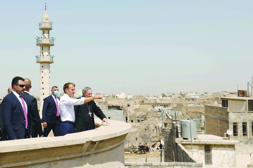 French President Emmanuel Macron (C) tours the Our Lady of the Hour Church in Iraq's second city of Mosul, in the northern Nineveh province, on Sunday. - AFP