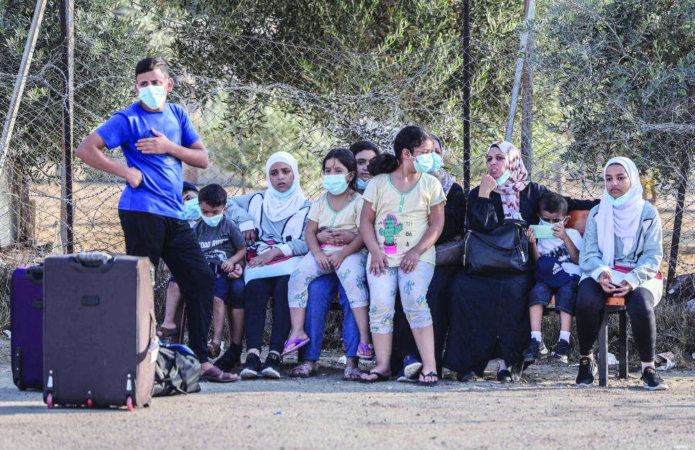 Palestinians wait their turn to cross into Egypt through the Rafah border crossing from the Gaza Strip on Sunday. - AFP