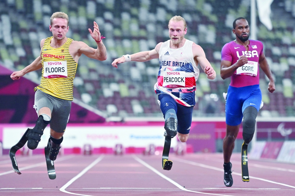 Germany's Johannes Floors (L), Britain's Jonnie Peacock (C) and USA's Jonathan Gore (R) cross the finish line in the men's 100m (T64) athletics final during the Tokyo 2020 Paralympic Games. -- AFP 