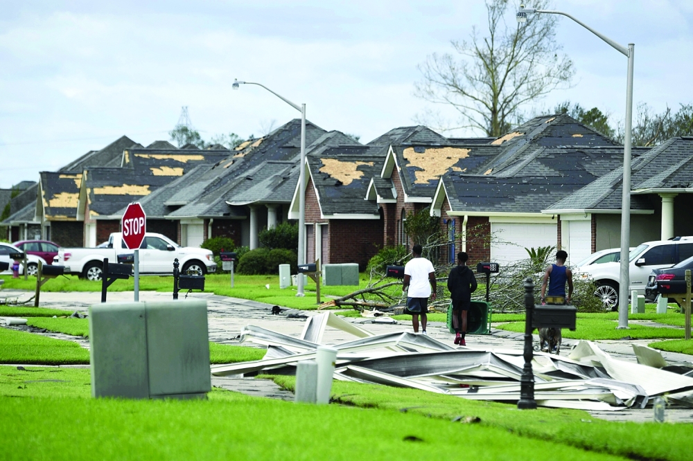 People look at debris damage in Laplace, Louisiana after Hurricane Ida made landfall. - AFP