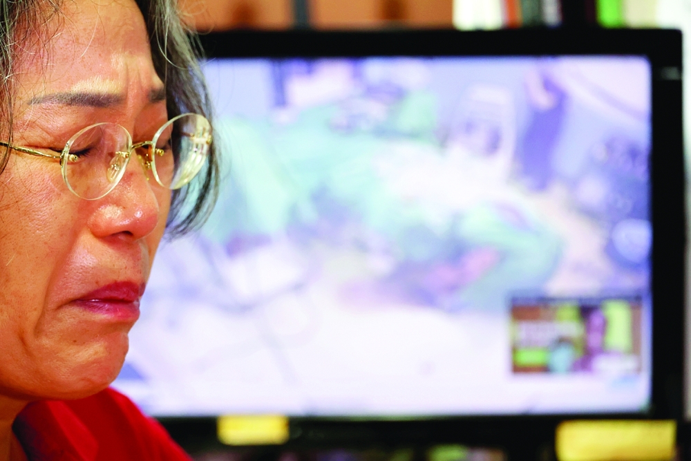 Lee Na-geum, whose son died after undergoing jawline plastic surgery reacts during an interview in Seoul. -- Reuters