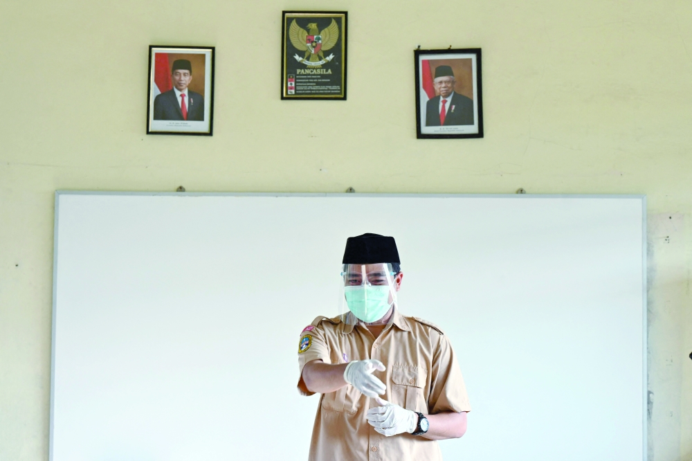 A teacher gestures in a classroom at a school after some schools reopened following restrictions due to Covid-19 in Jakarta on Wednesday. - AFP
