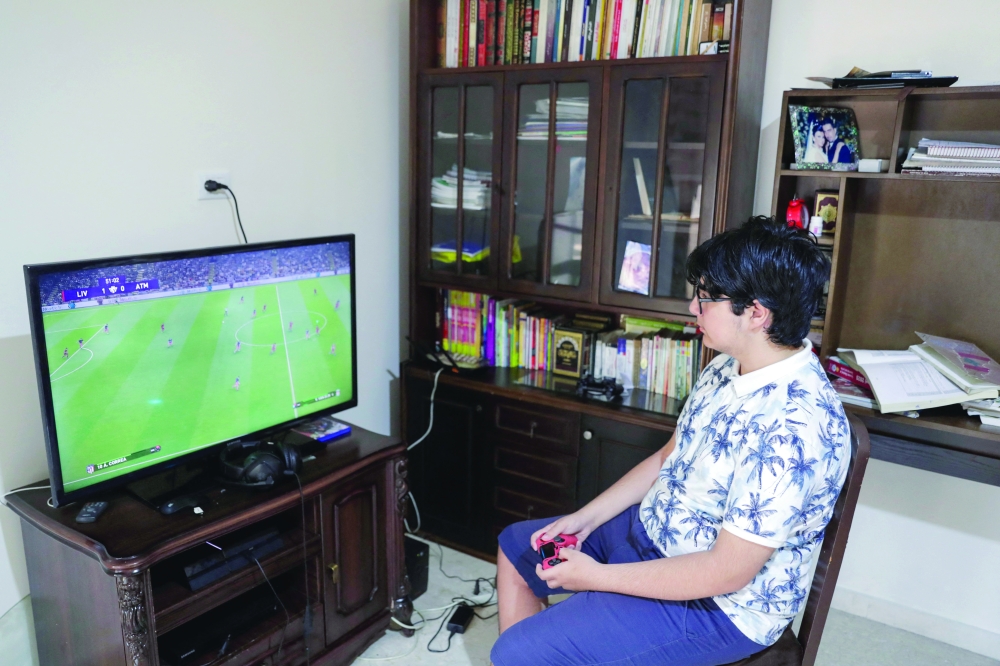 Lebanese pupil Rayan Mrad, 14, plays a video game at home in Beirut. - AFP