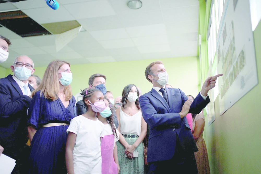 French President Emmanuel Macron addresses pupils during a visit at Bouge elementary school in Marseille,
southern France, on Thursday. — AFP