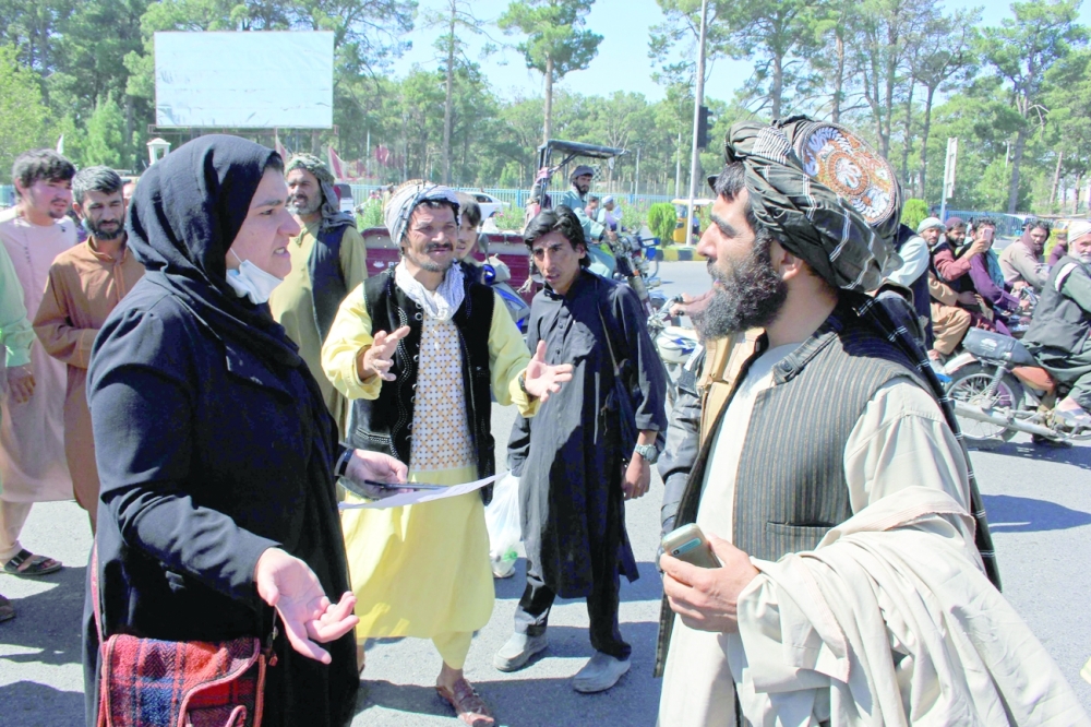 An Afghan woman protester speaks with a member of the Taliban during a protest in Herat. Defiant Afghan women held a rare protest on Thursday saying they were willing to accept the all-encompassing burqa if their daughters could still go to school under Taliban rule. -- AFP

