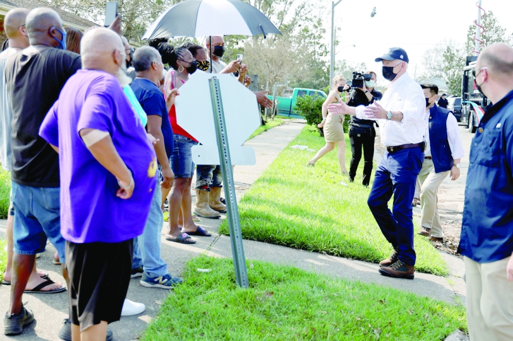 U.S. President Joe Biden talks to residents as he tours a neighborhood hit by Hurricane Ida in LaPlace, Louisiana, on Friday. -- Reuters