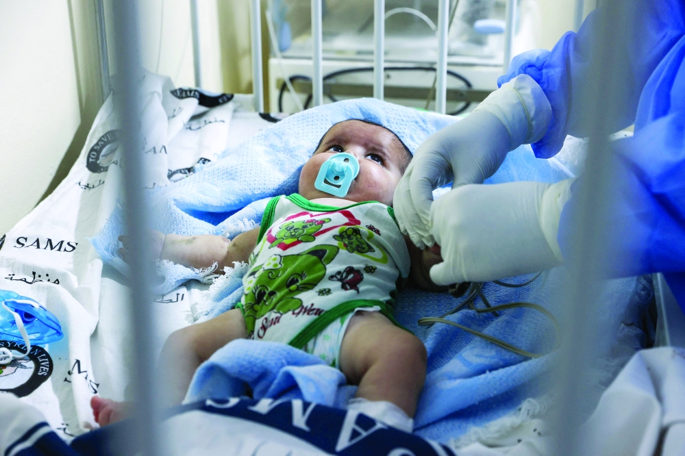 A Syrian medic cares for a baby at a newly opened Covid-19 isolation ward in the rebel-held northwestern city of Idlib, on Sunday. - AFP