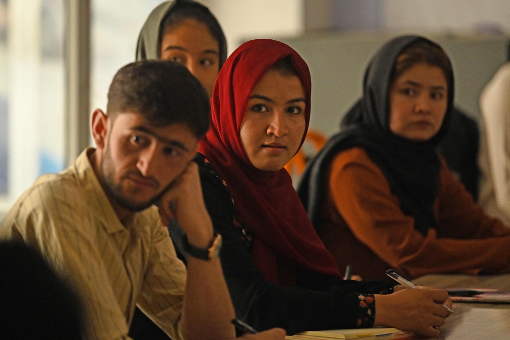 Students attend their class after private universities were reopened in Kabul on September 6, 2021. Women attending private Afghan universities must wear an abaya robe and niqab covering most of the face, the Taliban have ordered, and classes must be segregated by sex -- or at least divided by a curtain. (Photo by Aamir QURESHI / AFP)

