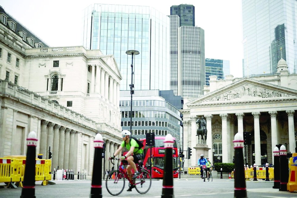 The Bank of England can be seen as people cycle through the City of London financial district, in London. - Reuters File 