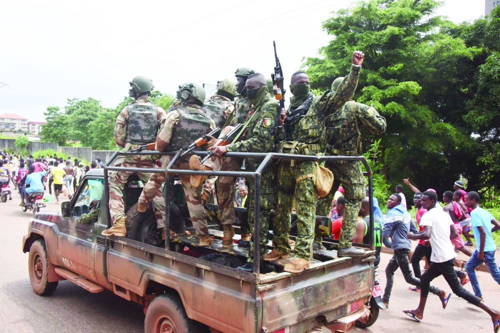 People celebrate in the streets with members of Guinea's armed forces after the arrest of Guinea's president, Alpha Conde, in a coup d'etat in Conakry, - AFP