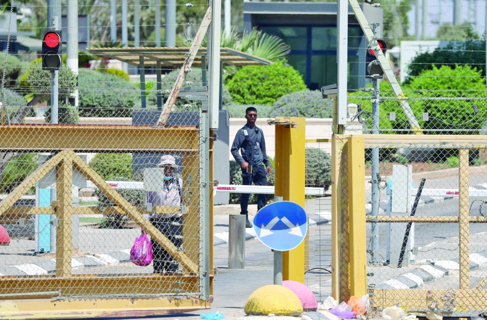 A member of the Israeli security forces watches a Palestinian man cross through the Al Jalama checkpoint on Monday. - AFP