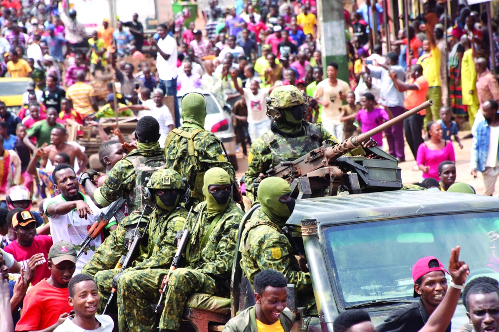 People celebrate in the streets with members of Guinea's armed forces after the arrest of Guinea's president, Alpha Conde, in a coup d'etat in Conakry, - AFP
