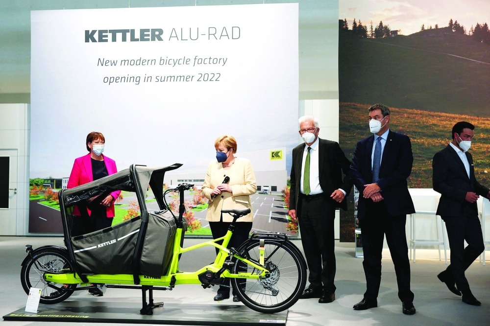 German Chancellor Angela Merkel takes a look at a Kettler Cargo E-Bike at the International Motor Show (IAA) Germany, after the fair's official opening in Munich. - AFP