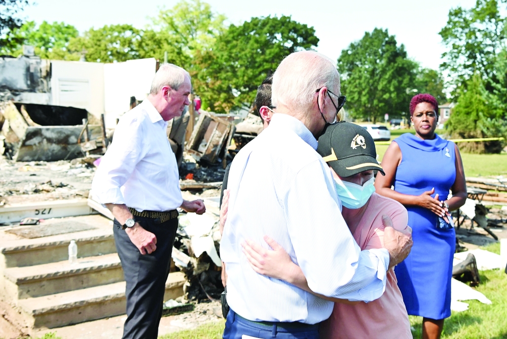 US President Joe Biden embraces a person as he tours a neighbourhood affected by Hurricane Ida in Manville, New Jersey. — AFP