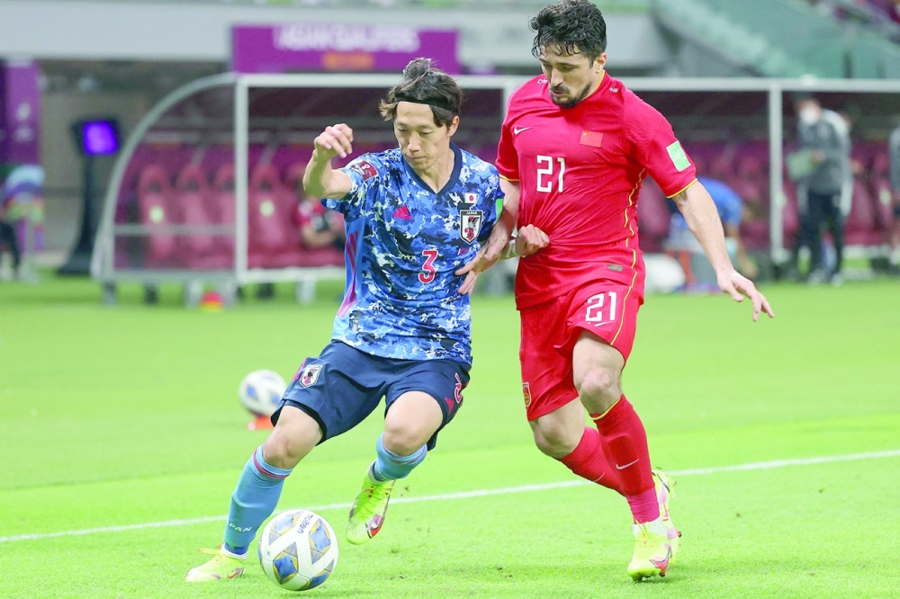 Japan's defender Sei Muroya (L) is marked by China's forward Aloisio during the 2022 Qatar football World Cup Asian Qualifiers match between China and Japan, at the Khalifa International stadium in Doha, on September 7, 2021. (Photo by KARIM JAAFAR / AFP)


