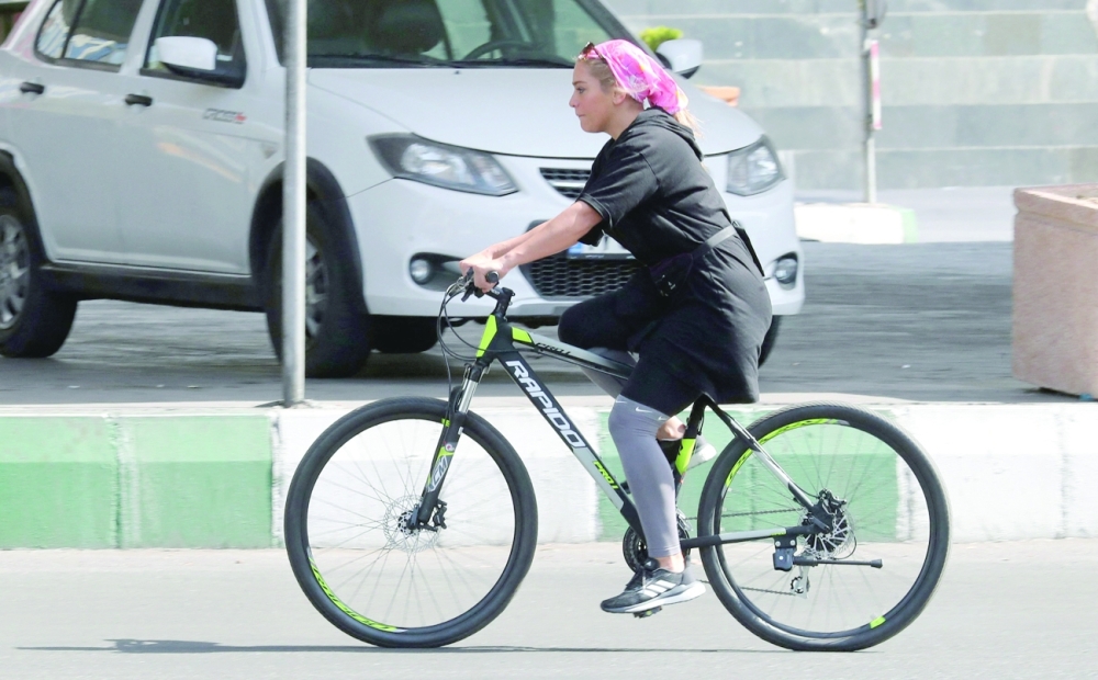 An Iranian woman rides a bicycle in Tehran. -- AFP
