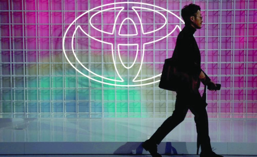 A man walks past a Toyota logo at the Tokyo Motor Show in Tokyo. - Reuters File 
