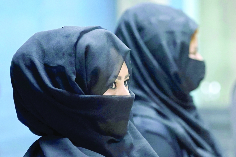 Afghan women airport workers at a security checkpoint of the airport in Kabul on Sunday. - AFP