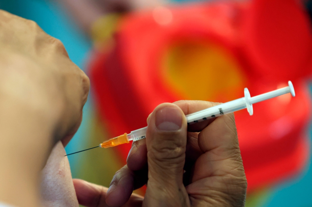 An ederly patient receives the 3rd dose of the Pfizer-BioNtech Covid-19 vaccine in Paris, on September 13, 2021.  France decided to offer a Covid booster shots to the elderly and vulnerable from September, joining a growing list of countries offering third vaccine shots to fight new virus variants, President Emmanuel Macron said on August 5. 2021.
 (Photo by THOMAS COEX / AFP)
