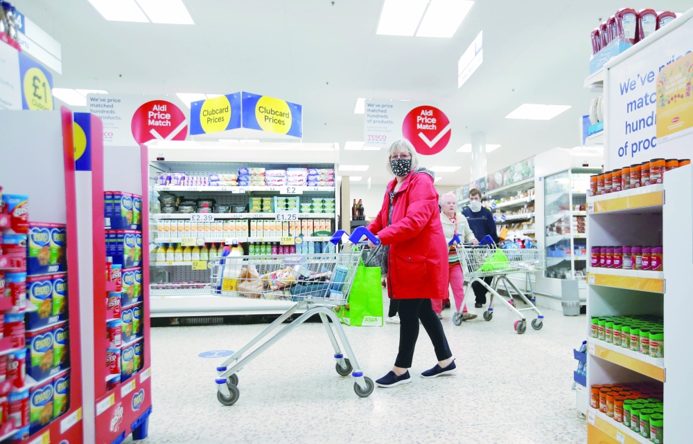 A woman pushes a shopping cart at a Tesco supermarket in Hatfield, Britain. - Reuters File
