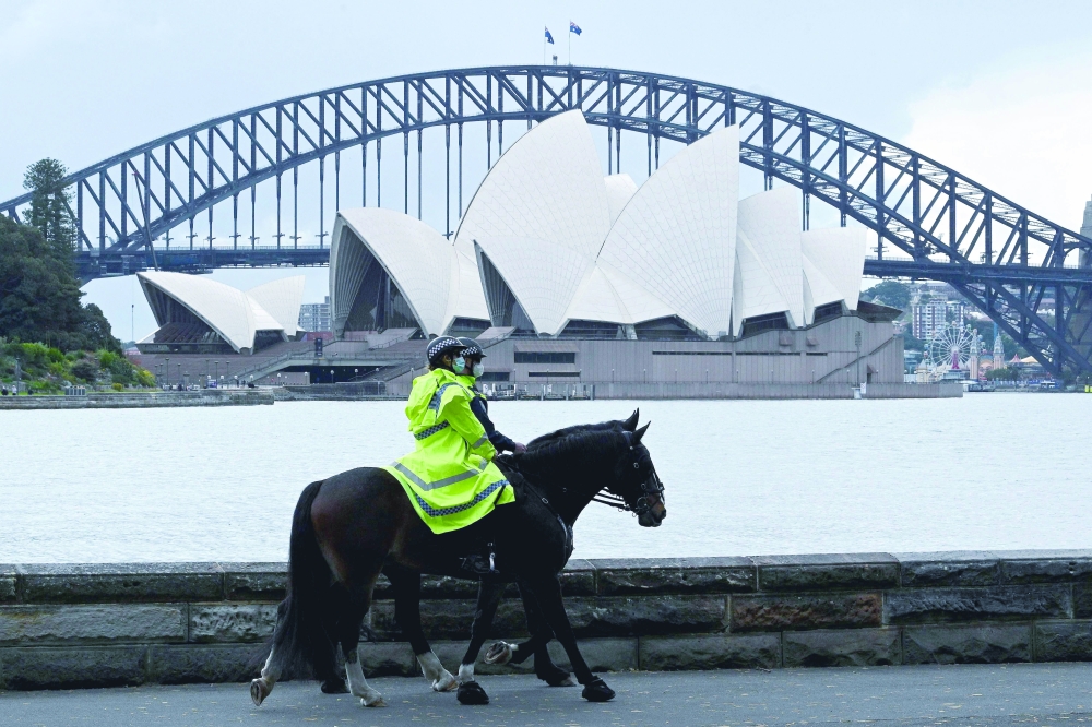 Policer offers patrol on their service horses in front of the Sydney Opera House amid Covid-19 pandemic. - AFP