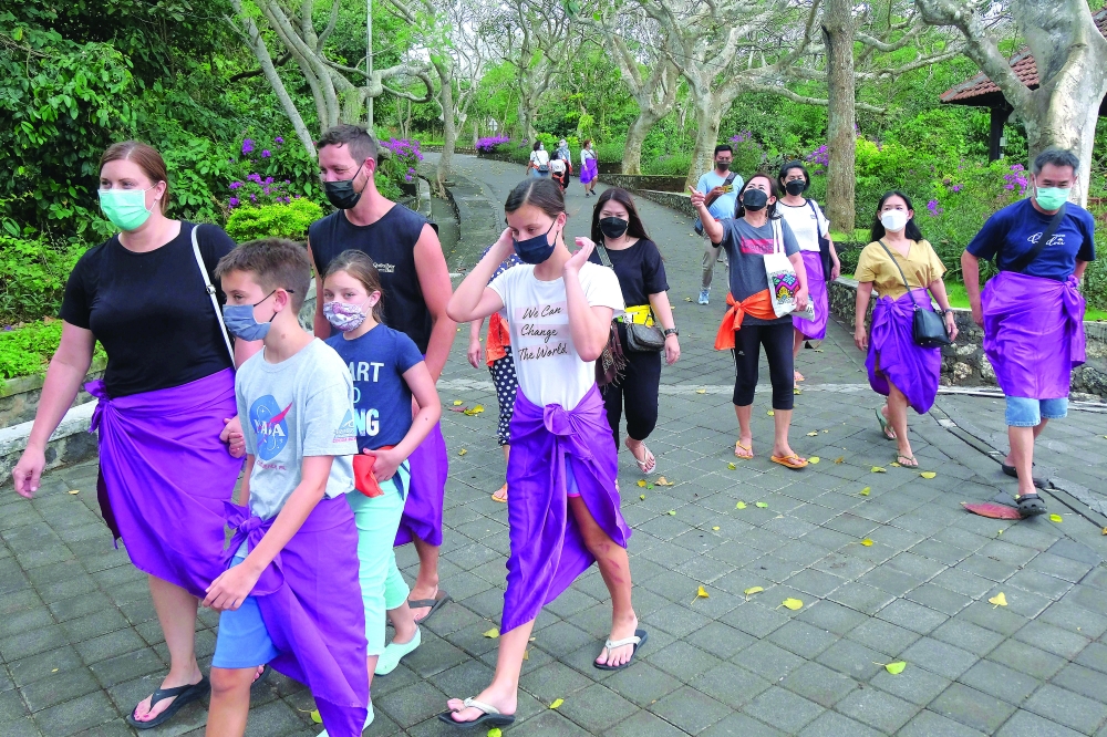 People wear protective face masks on the first day of trial opening for tourist attractions in Badung, Bali, on Monday. - Reuters