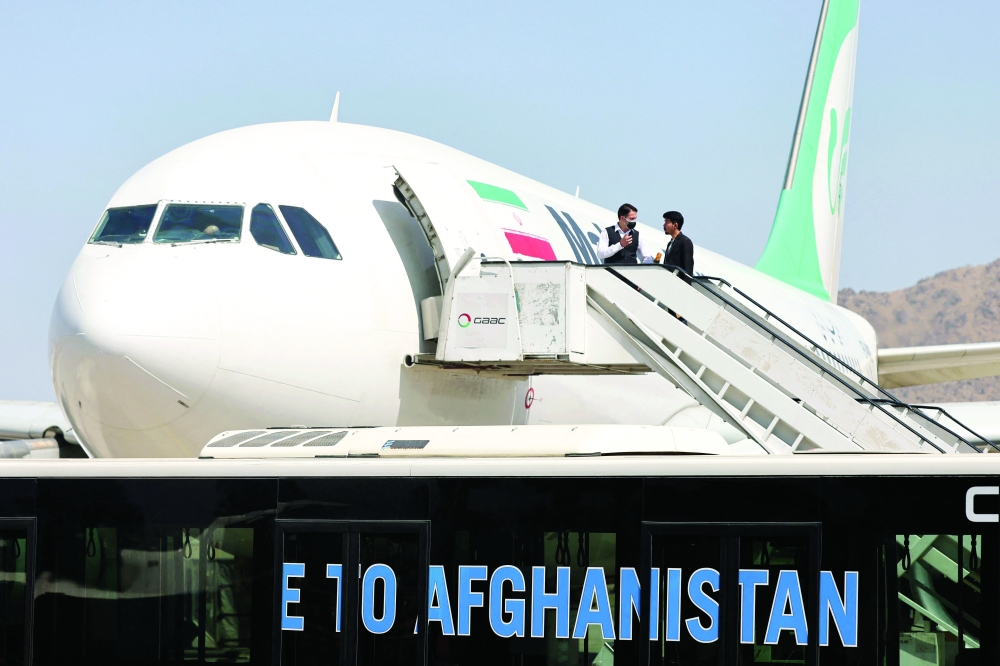 Passengers get off a Mahan Air aircraft at the airport in Kabul on Wednesday. - AFP