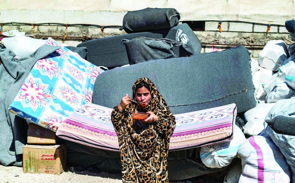 A picture taken at the Kurdish-run Al Hol camp shows families preparing for their released from the camp to return home in Raqqa region. - AFP