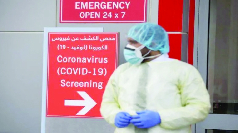 A security guard wearing protective equipment watches over patients queuing to be tested at the Cleveland Clinic hospital in Abu Dhabi. -- Reuters
