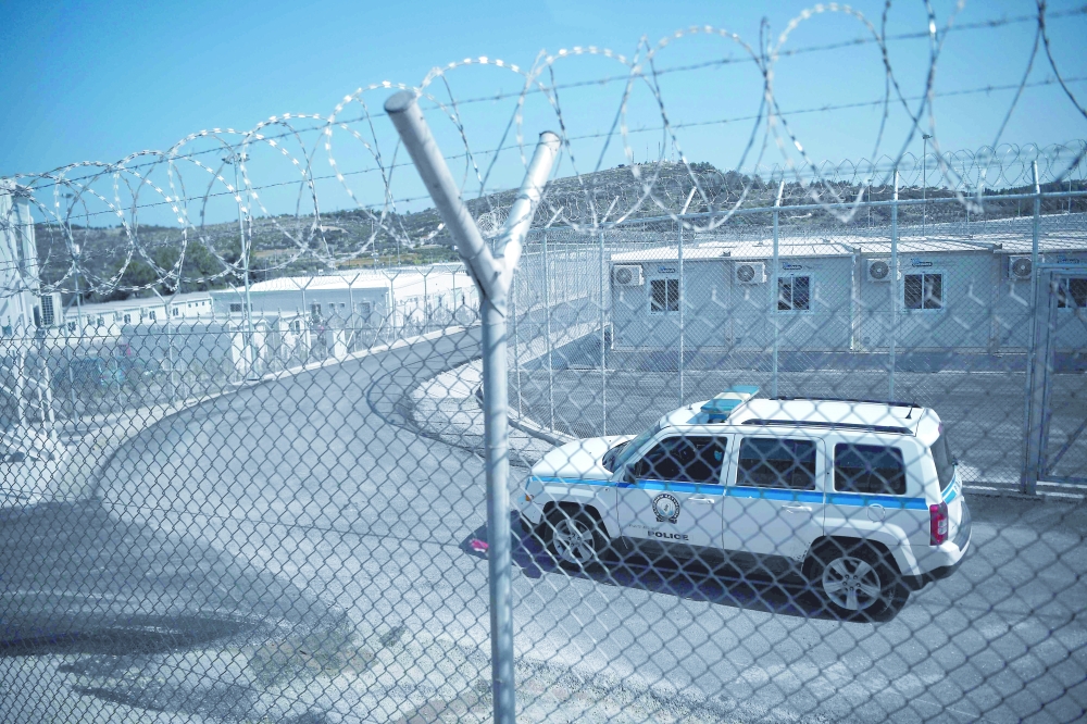 A police car patrols in the streets of the EU-funded multi-purpose RIC of migrants on the island of Samos. - AFP
