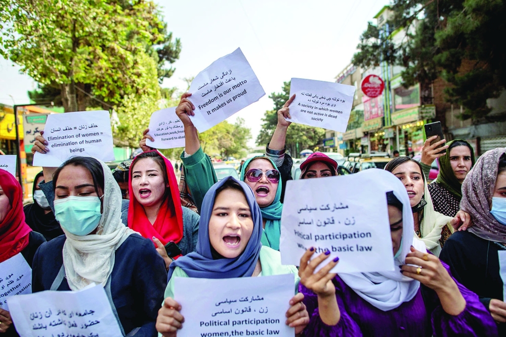 Afghan women hold placards during a demonstration demanding better rights for women in front of the former Ministry of Women Affairs in Kabul on Sunday. - AFP