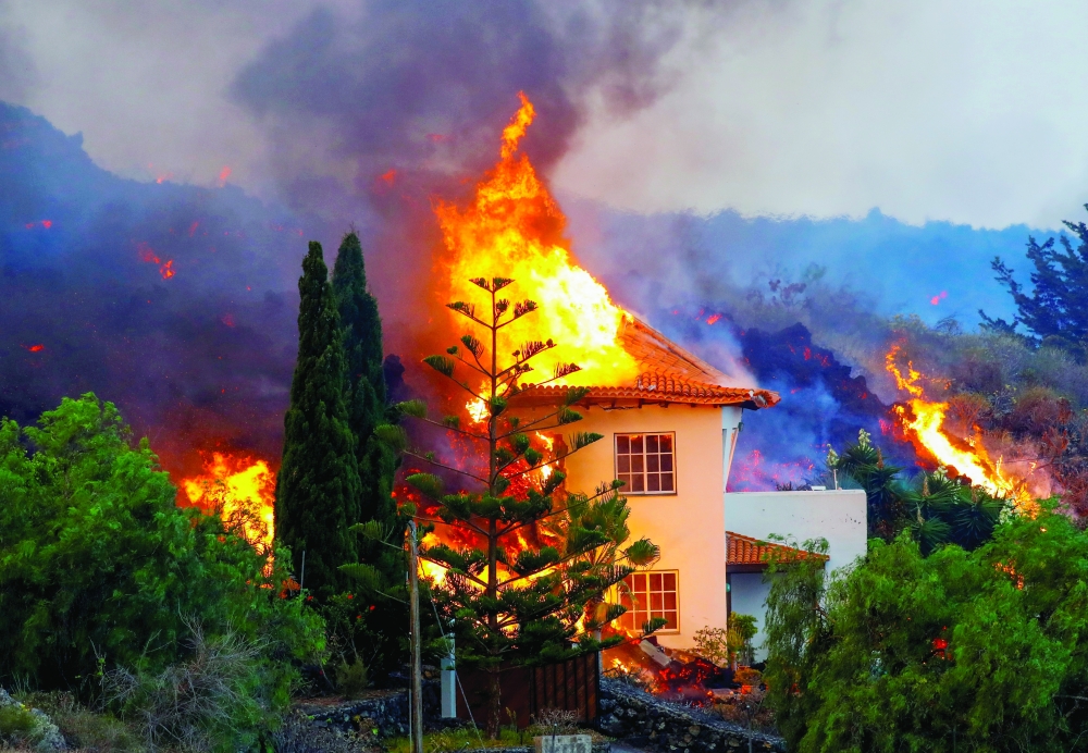 A house burns due to lava from the eruption of a volcano in the Cumbre Vieja national park at Los Llanos de Aridane, on the Canary Island of La Palma. - Reuters

