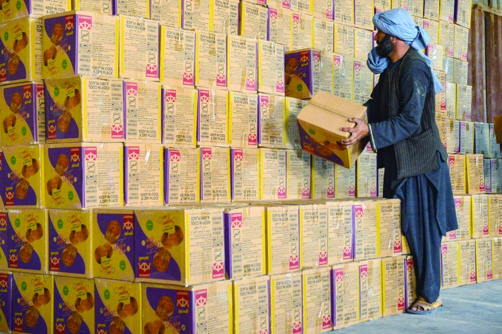 Afghan men work at a customs office warehouse in Herat on Monday. - AFP