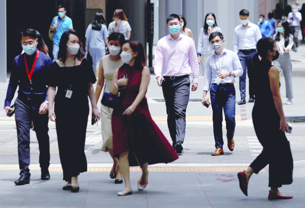 Office workers spend their lunch breaks at the central business district in Singapore. - Reuters