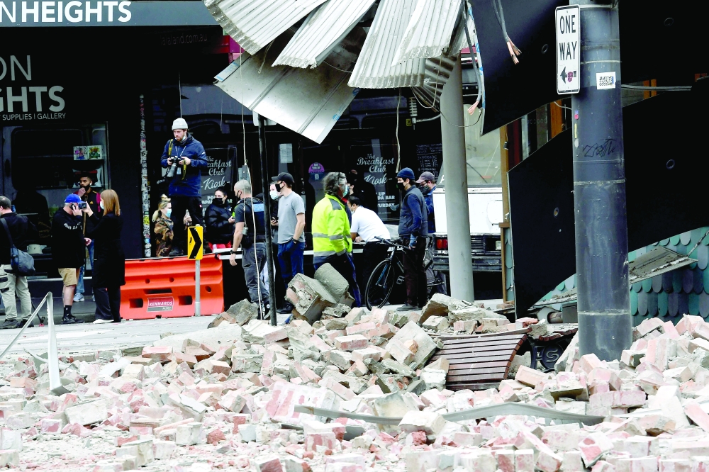 People gather near a damaged building in the popular shopping Chapel Street in Melbourne after a 5.8-magnitude earthquake. - AFP