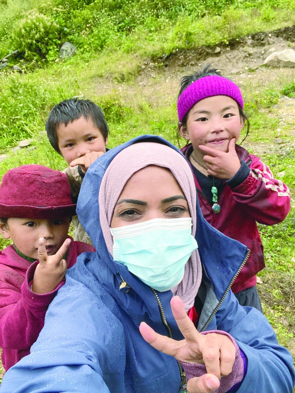 Nadhirah al Harthy with children at the foot of Manaslu. It is standing head and shoulders above the pine forests of Nepal's Budhi Gandak river valley. The mighty Manaslu is nicknamed 'killer mountain' by the local people in Nepal. 