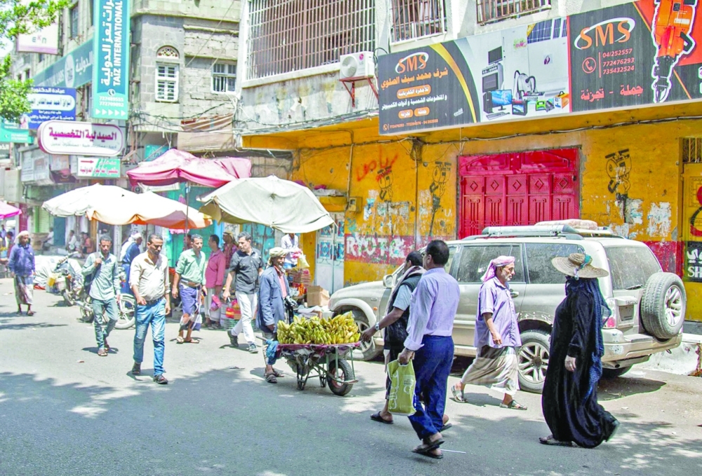 People walk along a street past shops that have been closed as part of a wider strike by merchants in protest against deteriorating economic and living conditions due to the prolonged state of conflict, in Taez. -- AFP