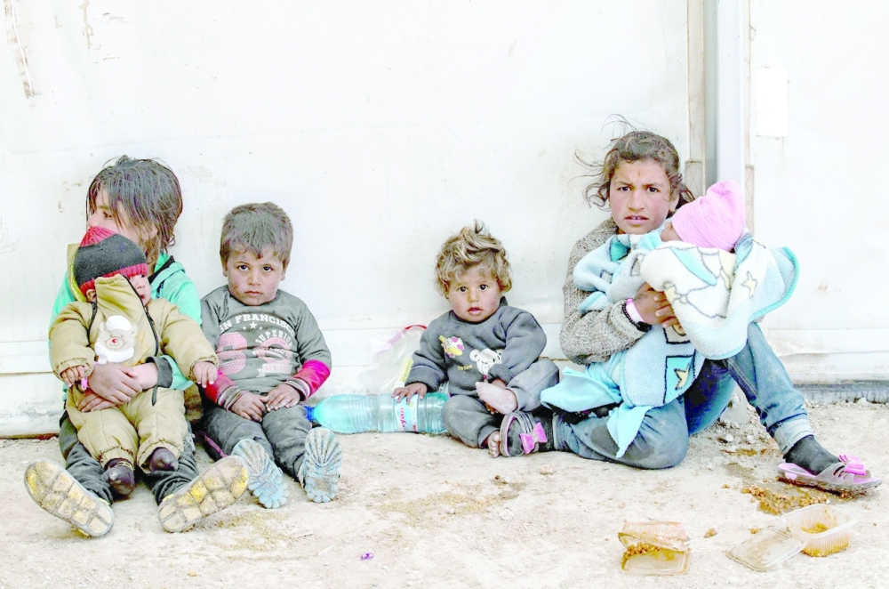 Syrian women and children siting at the Kurdish-run al-Hol camp which holds suspected relatives of IS group fighters, in Hasakeh governorate of northeastern Syria. 
