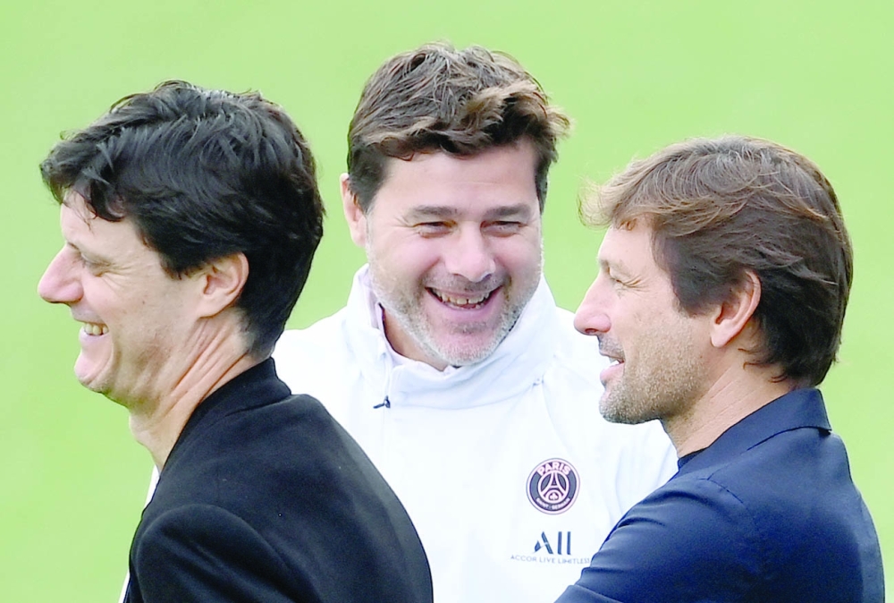 Paris Saint-Germain's head coach Mauricio Pochettino (C) jokes with sporting director Leonardo (R) and deputy sporting director Angelo Castellazzi (L) during a training session. -- AFP

