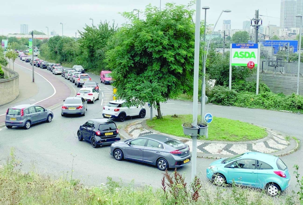 An aerial view shows customers queueing in their cars to access an Asda petrol station in east London. -- AFP

